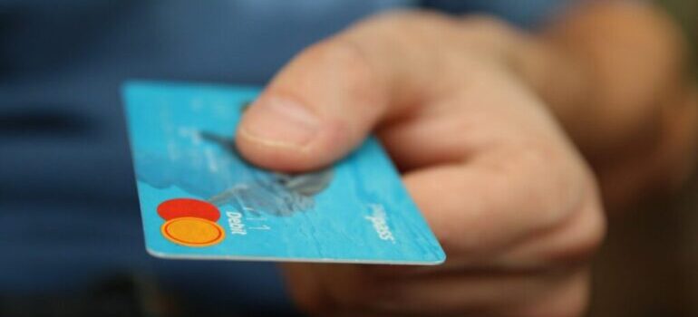 A person holding a blue credit card.