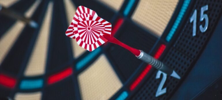 A red and white dart hitting a target.