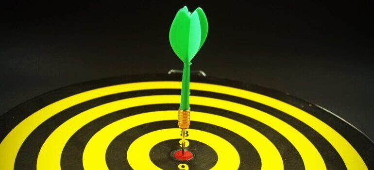 A green dart at the center of a target.
