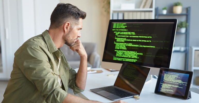 Guy looking at code on screen