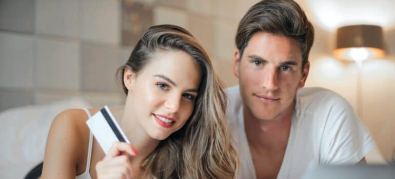 A woman and a man holding a credit card.