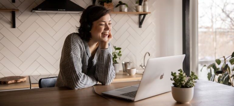 Woman looking at laptop and smiling.