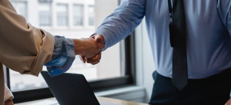People in professional attire shaking hands.
