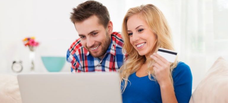 A couple doing online shopping and smiling.