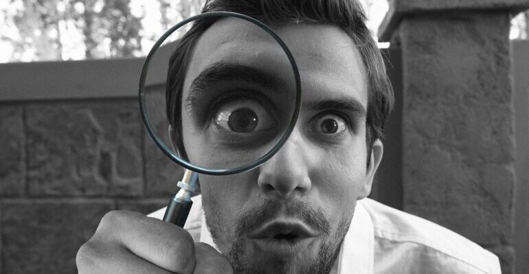 A man looking through a magnifying glass.