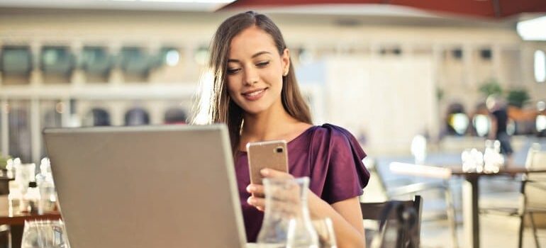 A satisfied woman reading marketing content on her phone showing why you need to use CRM for eCommerce personalization.