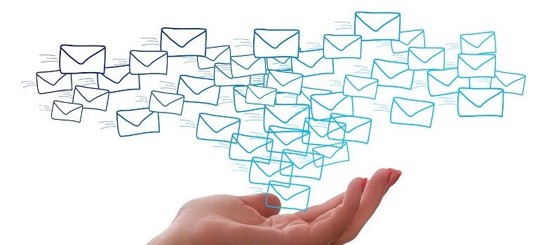 A hand giving out numerous emails, giving a visual representation of mass email marketing.