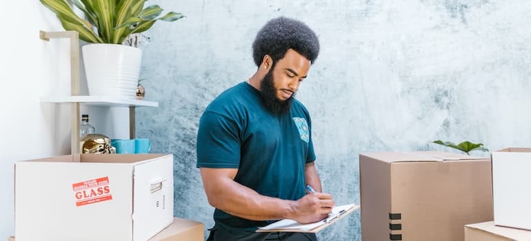 Professional mover doing paperwork he wouldn't have to if he found ways to improve your moving company's billing and invoicing