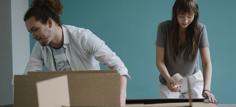 A couple preparing moving boxes after learning theimportance of reliable CRM software support