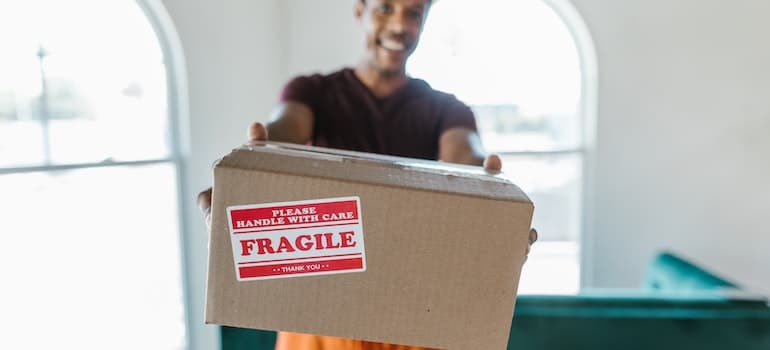 A mover with a moving box satisfied after learning how CRM analytics improve moving operations