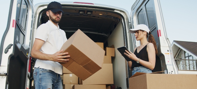Two people packing boxes in a moving truck
